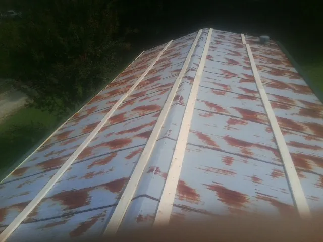 Rusted metal roof panels with new wood purlins before replacement — Storm Damage Roof Repair in Warrenton by Roofing Brothers
